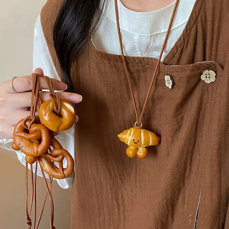 Exquisitely - crafted and adorably - shaped small pendants in the form of hand - made pretzels.